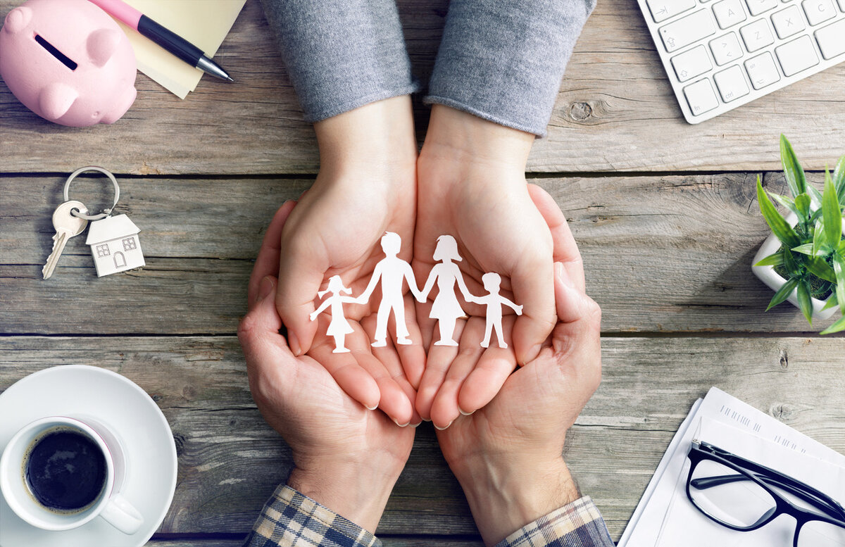 Family holding paper cutout figures representing life insurance protection and planning
